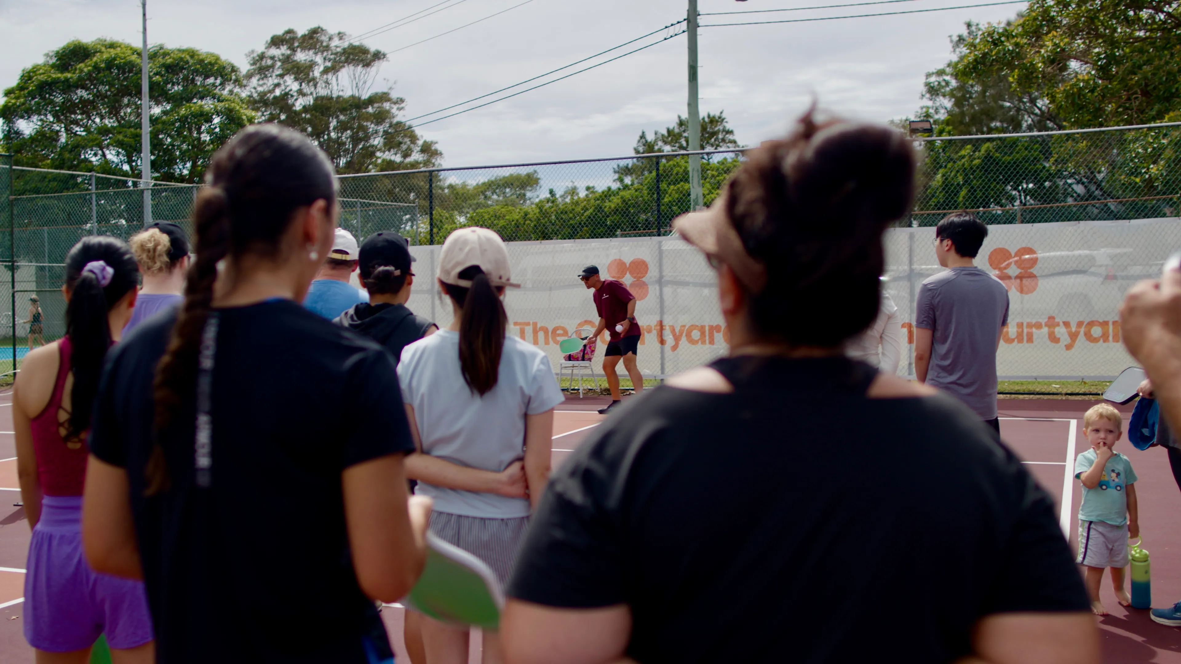 Group of players laughing together on the pickleball court